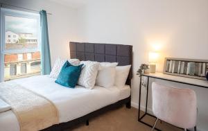 une chambre avec un grand lit avec une fenêtre dans l'établissement Modern Downtown Gem- Brand New Apartments on Cannon St, à Preston