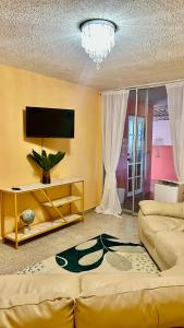 a living room with a couch and a flat screen tv at Jacuzzi Hideaway in San Juan