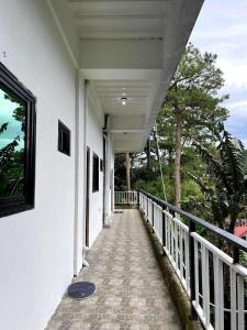 a porch of a white house with a walkway at Aga's Transient House in Baguio
