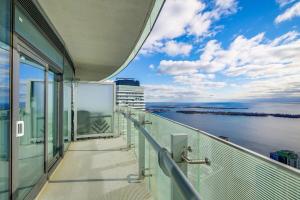 a balcony of a building with a view of the water at Luxury 1BR Suite 65th Floor - Lake & Island View! in Toronto