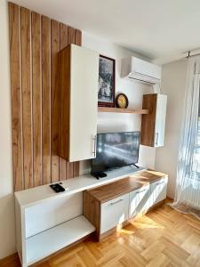 - une cuisine avec des placards blancs et un mur en bois dans l'établissement Vidolux Studio, à Niš 23 autres photos