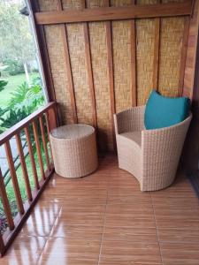 シンガラジャにあるHome Nuh Umajeroの籐椅子付きのポーチ