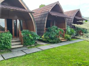 a house with a wooden roof and a yard at Home Nuh Umajero in Singaraja