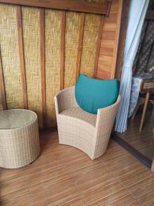 シンガラジャにあるHome Nuh Umajeroの籐の椅子(テーブルの横に青い枕付)