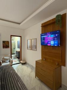 ein Schlafzimmer mit einem Flachbildfernseher an der Wand in der Unterkunft Casa aconchegante - Green Village - Praia do Cassino in Rio Grande