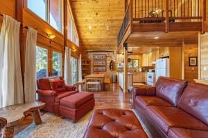 a living room with leather furniture and a kitchen at Straight From The Heart cabin in Lyle
