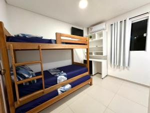 a bedroom with two bunk beds with blue sheets at Suíte Estrela-do-Mar 1 - Pé na Areia in Maragogi