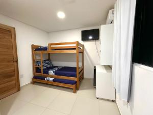 a small room with bunk beds and a television at Suíte Estrela-do-Mar 1 - Pé na Areia in Maragogi +10 photos