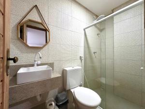 a bathroom with a toilet and a sink and a mirror at Suíte Estrela-do-Mar 1 - Pé na Areia in Maragogi