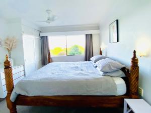 a bedroom with a large bed with a window at 2Br Apartment, Pool, 12 mins to Airport in Bilambil Heights +9 photos