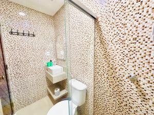 a bathroom with a toilet and a glass shower at Suíte Estrela-do-Mar 2 - Pé na Areia in Maragogi