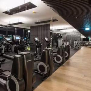 a gym with a row of treadmills and machines at Fortitude Valley Stylish Comfortable Apartment in Brisbane