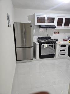 a kitchen with stainless steel appliances and white cabinets at Eastern Breeze in Hainamosa