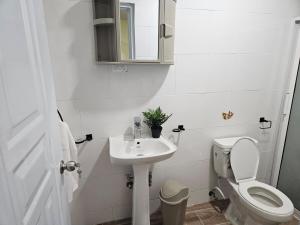 a white bathroom with a toilet and a sink at Eastern Breeze in Hainamosa +19 photos