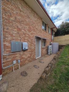 a brick building with a tv on the side of it at The Studio on Ashtree in Armidale +2 photos