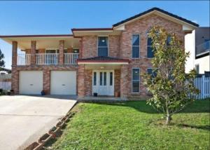 a large brick house with two garage at The Studio on Ashtree in Armidale