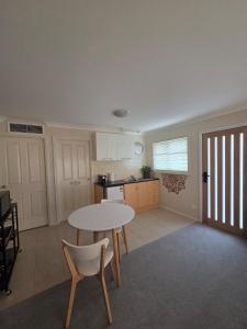 a kitchen with a table and chairs in a room at The Studio on Ashtree in Armidale