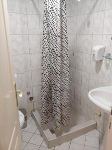 a bathroom with a shower with a leopard shower curtain at ViP HOTEL in Skopje +2 photos