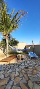 a palm tree and a hammock on a patio at Casa de Brotas com Piscina in Brotas