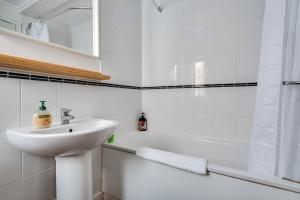 une salle de bain blanche avec un lavabo et une baignoire dans l'établissement Central Oxford Oasis - Close to Colleges and Shops, à Oxford 11 autres photos