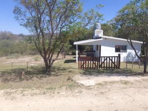 un petit bâtiment blanc avec un arbre devant dans l'établissement Monoambiente El Arcano, à Tanti