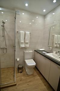 a bathroom with a toilet and a sink and a shower at La Casa Hotel in Tsigov Chark