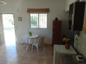 une pièce avec une table avec des chaises et une fenêtre dans l'établissement Monoambiente El Arcano, à Tanti 5 autres photos