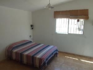 une chambre avec un lit dans une pièce avec une fenêtre dans l'établissement Monoambiente El Arcano, à Tanti