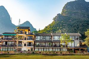 a large building with mountains in the background at Secret Garden Lakefront Hotel 连住两晚享高铁站免费接站 in Guilin