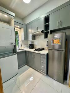 a kitchen with stainless steel appliances and gray cabinets at Affordable room near the beach in San Felipe de Puerto Plata +3 photos
