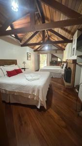 モンテ・ヴェルデにあるCapricho da Natureza Pousadaのウッドフロアの広いベッドルーム(ベッド2台付) +153枚の写真