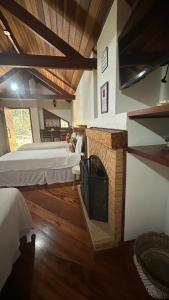 モンテ・ヴェルデにあるCapricho da Natureza Pousadaのベッド2台と暖炉付きの広い客室です。