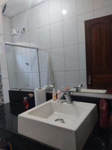 une salle de bain avec un lavabo blanc et un miroir dans l'établissement Cozy Retro Apartment!, à Pasto da Mata