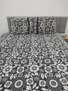 - un lit avec un couvre-lit et des oreillers noirs et blancs dans l'établissement Cozy Retro Apartment!, à Pasto da Mata