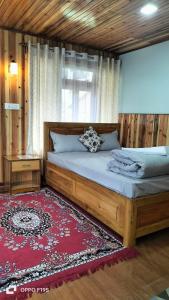 1 dormitorio con cama grande de madera y alfombra roja en Chyajalo homestay, en Darjeeling
