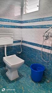 Un baño con inodoro y un cubo en el agua. en Chyajalo homestay, en Darjeeling