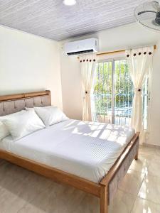 a bedroom with a bed and a large window at Apartamento vacacional por días en Santa Marta in Santa Marta
