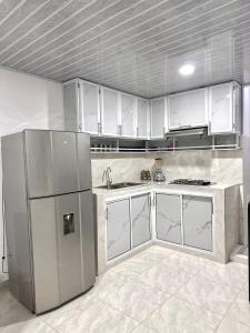 a kitchen with white cabinets and stainless steel appliances at Apartamento vacacional por días en Santa Marta in Santa Marta