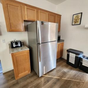 a stainless steel refrigerator in a kitchen with wooden cabinets at Home away from Home - 6 miles from the SNP in Three Rivers