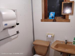 a bathroom with a toilet and a sink at Hospedaje Mirador del Puerto in Quellón