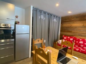 a kitchen with a table with a laptop on it at Serac Residence Val Thorens Condo in Val Thorens