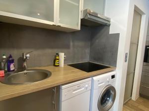 a kitchen with a sink and a washing machine at Serac Residence Val Thorens Condo in Val Thorens