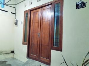 una porta di legno sul lato di un edificio di 563 Homestay Jogja a Ngabean Altre 6 foto