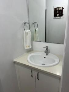 a bathroom with a sink and a mirror at 4 Beds Including 1 Sofa Bed in 1 Bedroom plus1 Lounge in Auckland +2 photos