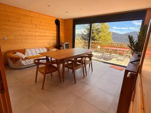 a dining room with a table and a large window at Chalet moderne 100m² pour 8 pers - Vue sur le lac - FR-1-758-44 in Les Angles