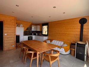 a kitchen and dining room with a table and a couch at Chalet moderne 100m² pour 8 pers - Vue sur le lac - FR-1-758-44 in Les Angles +4 photos