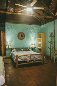 Un dormitorio con una cama y una pared azul. en Hostal Rosa Mística, en Montañita