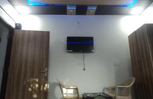 a room with two chairs and a tv on a wall at Corbett view homestay in Belparāo