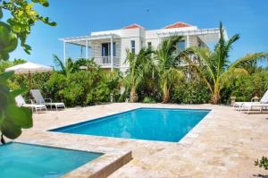 a villa with a swimming pool and a house at Wyakha 1 Garden View in Long Bay Hills