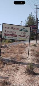 un panneau situé au bord d'une route dans l'établissement Umm Aljulud Cottages, à Ajloun